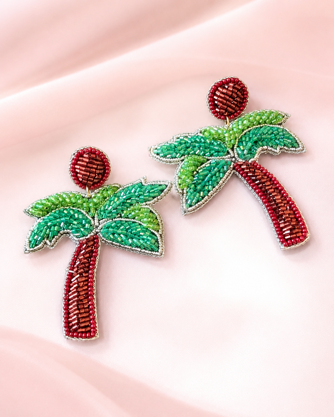 Handmade Tropical Palm Tree Beaded Statement Earrings for Women | Vacation & Resort Jewelry — Handmade red and green beaded palm tree statement earrings by ZOHRICANADA on a pink background — Zohricanada