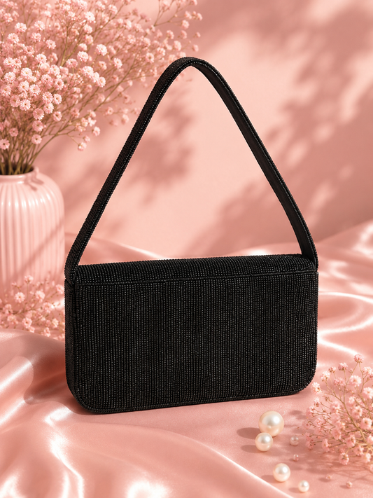 Handmade Black Beaded Celestial Evening Bag for Women | Wedding & Date Night Shoulder Bag — Back view of black beaded Midnight Celestial shoulder bag by ZOHRICANADA on a pink satin background with dried flowers and pearls — Zohricanada