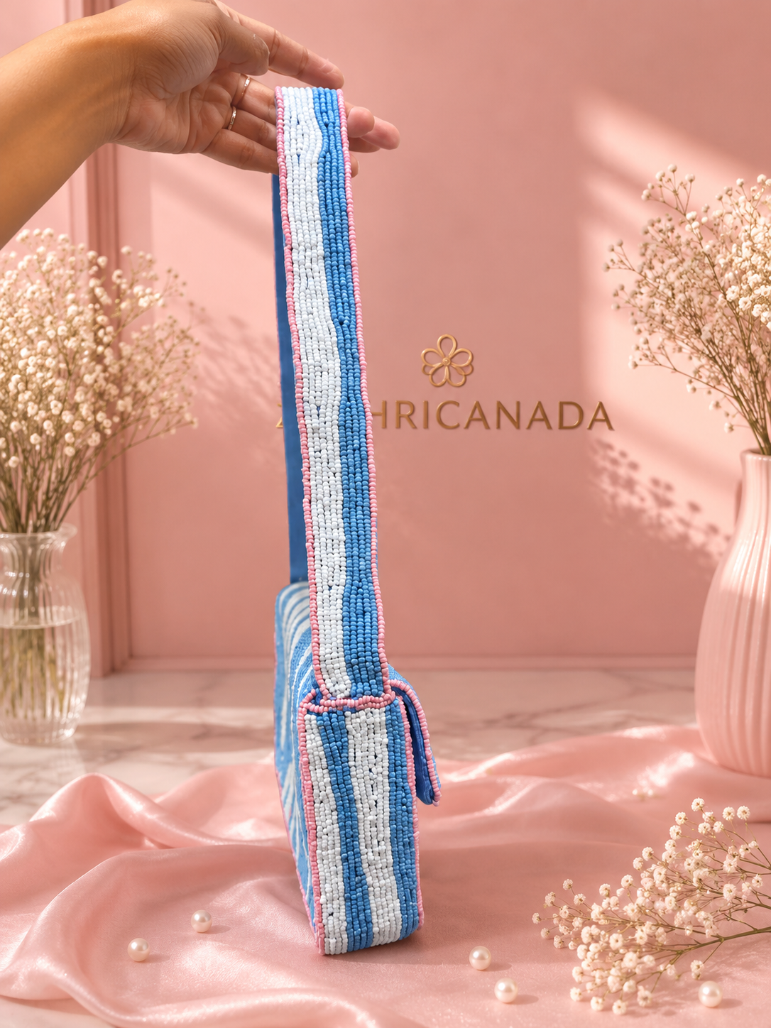 Handmade Blue & White Striped Beaded Shoulder Bag for Women | Beach & Resort Handbag — Close-up of the woven strap on a blue, white, and pink striped beaded shoulder bag by ZOHRICANADA, shown against a pink backdrop — Zohricanada