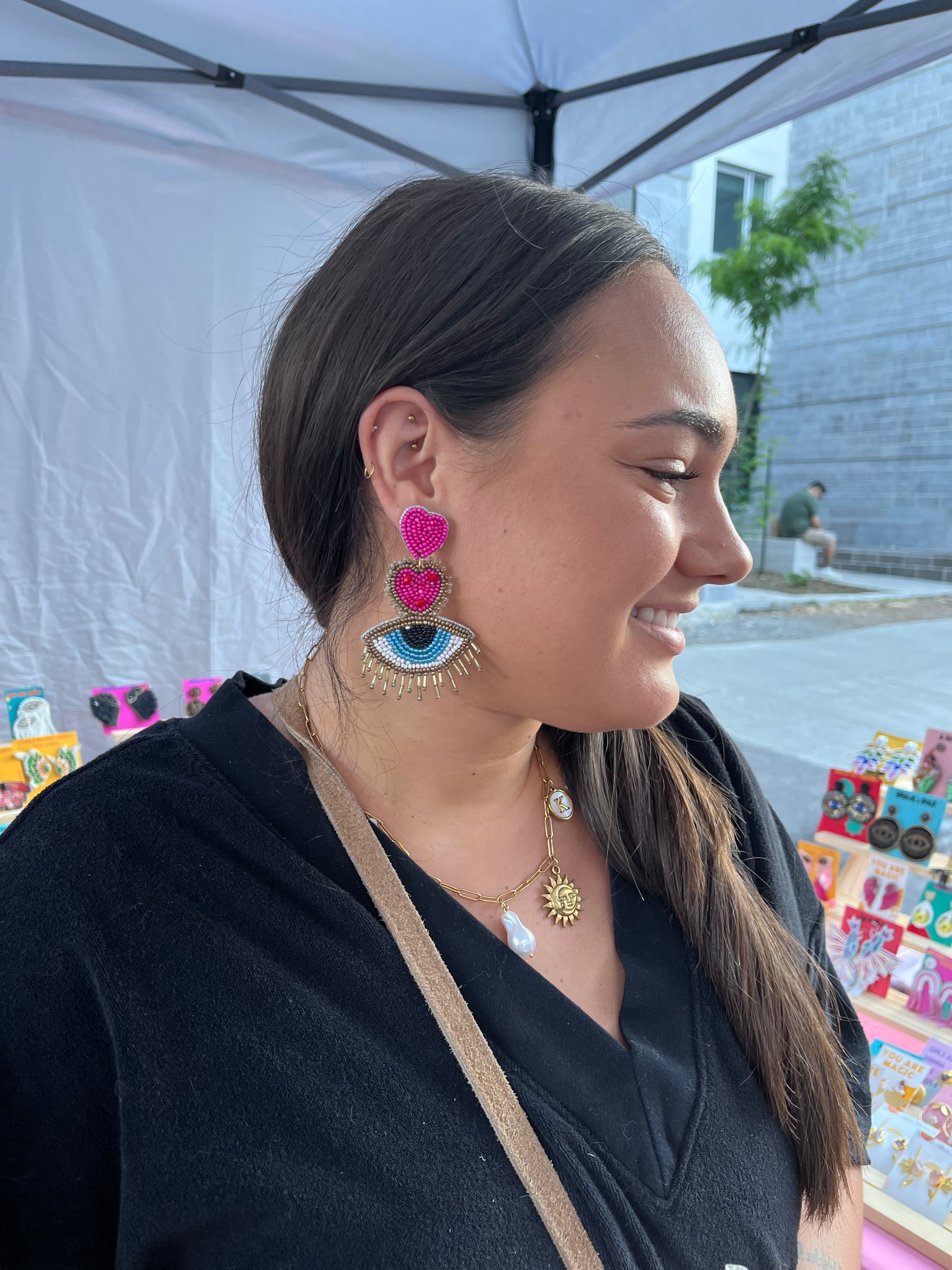 Customer wearing handmade pink heart and evil eye beaded statement earrings | Zohricanada