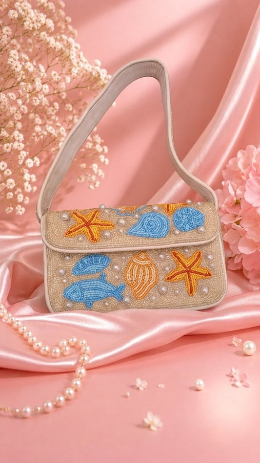 Oh my Star Fish Beach bag — A beige embroidered shoulder bag with an ocean-themed design featuring blue seashells, orange starfish, and a blue fish, styled on pink satin with pearl beads and dried flowers. — Zohricanada