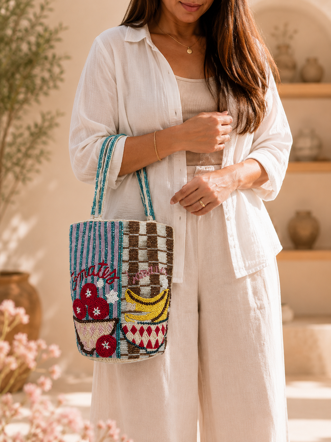 Handmade Fruit Market Beaded Tote Bag for Women | Luxury Vacation & Gift Handbag — Woman in a linen outfit carrying a handmade beaded fruit market tote bag by ZOHRICANADA with tomato and banana embroidery — Zohricanada