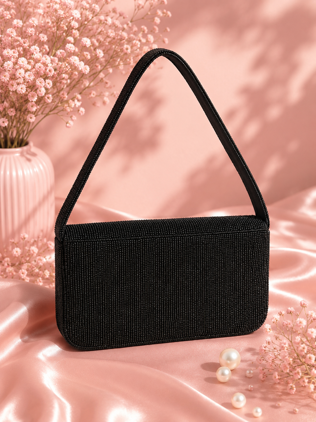 Handmade Black Beaded Celestial Evening Bag for Women | Wedding & Date Night Shoulder Bag — Back view of black beaded Midnight Celestial shoulder bag by ZOHRICANADA on a pink satin background with dried flowers and pearls — Zohricanada